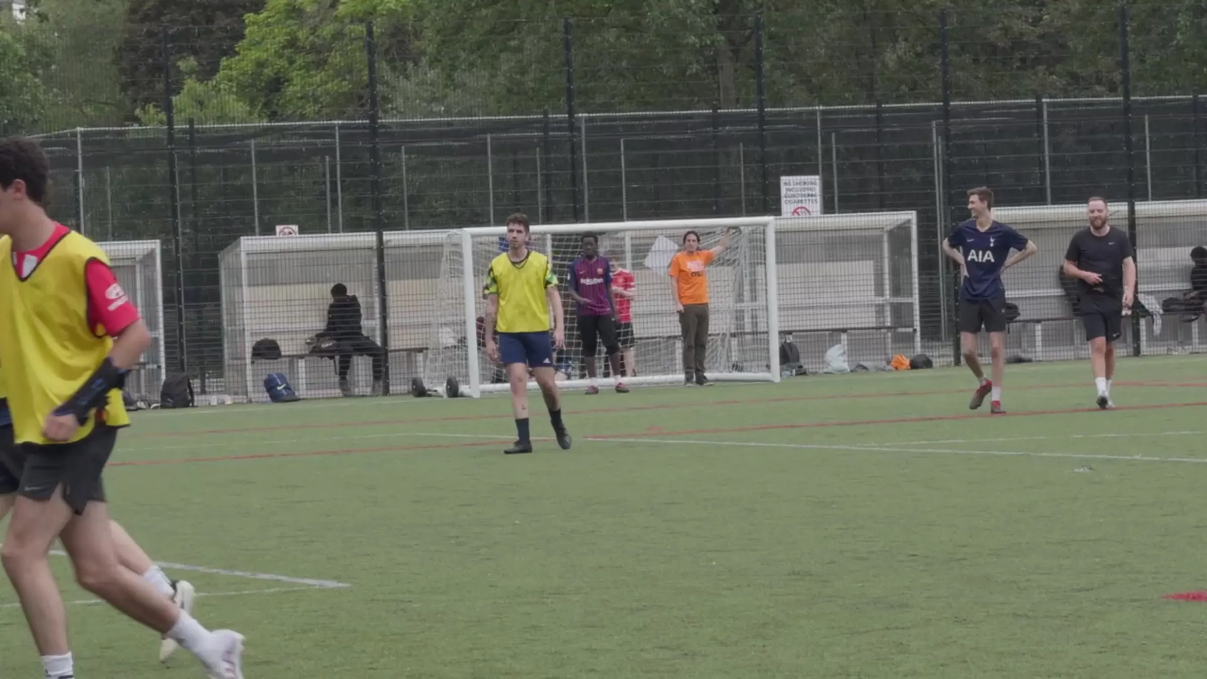 A five-a-side football match on an outdoor pitch, with Graham standing near the goal
